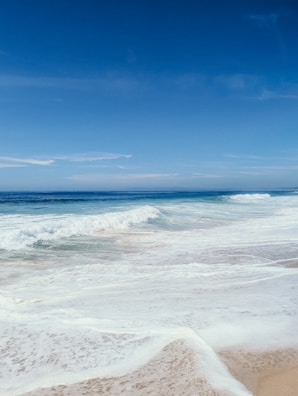 A tranquil beach scene with gentle waves and soft sand.
