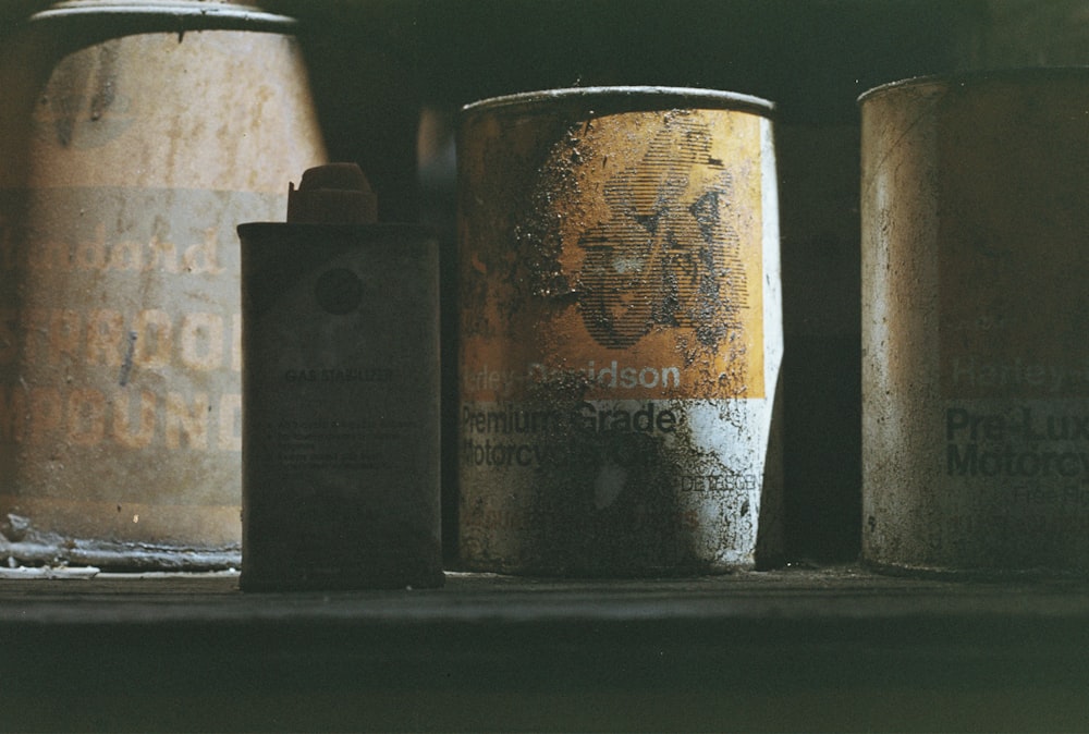 a group of old tins sitting on top of a shelf