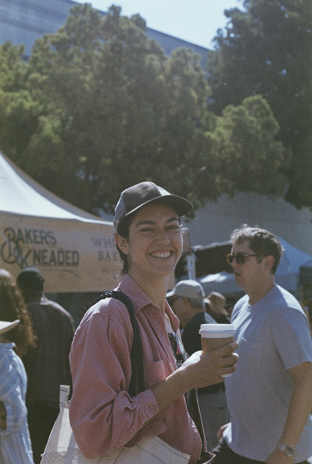 a smiling woman holding a cup of coffee