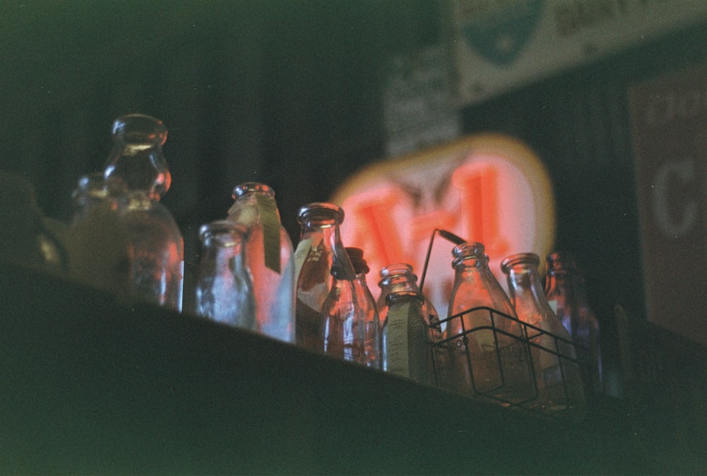 um grupo de garrafas de vidro sentado em cima de uma prateleira