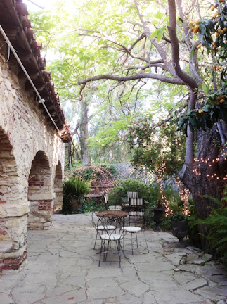 Rustic outdoor patio paved with warm terracotta tiles surrounded by greenery.