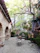 A cozy backyard patio surrounded by natural stone retaining walls and lush greenery under soft evening light.