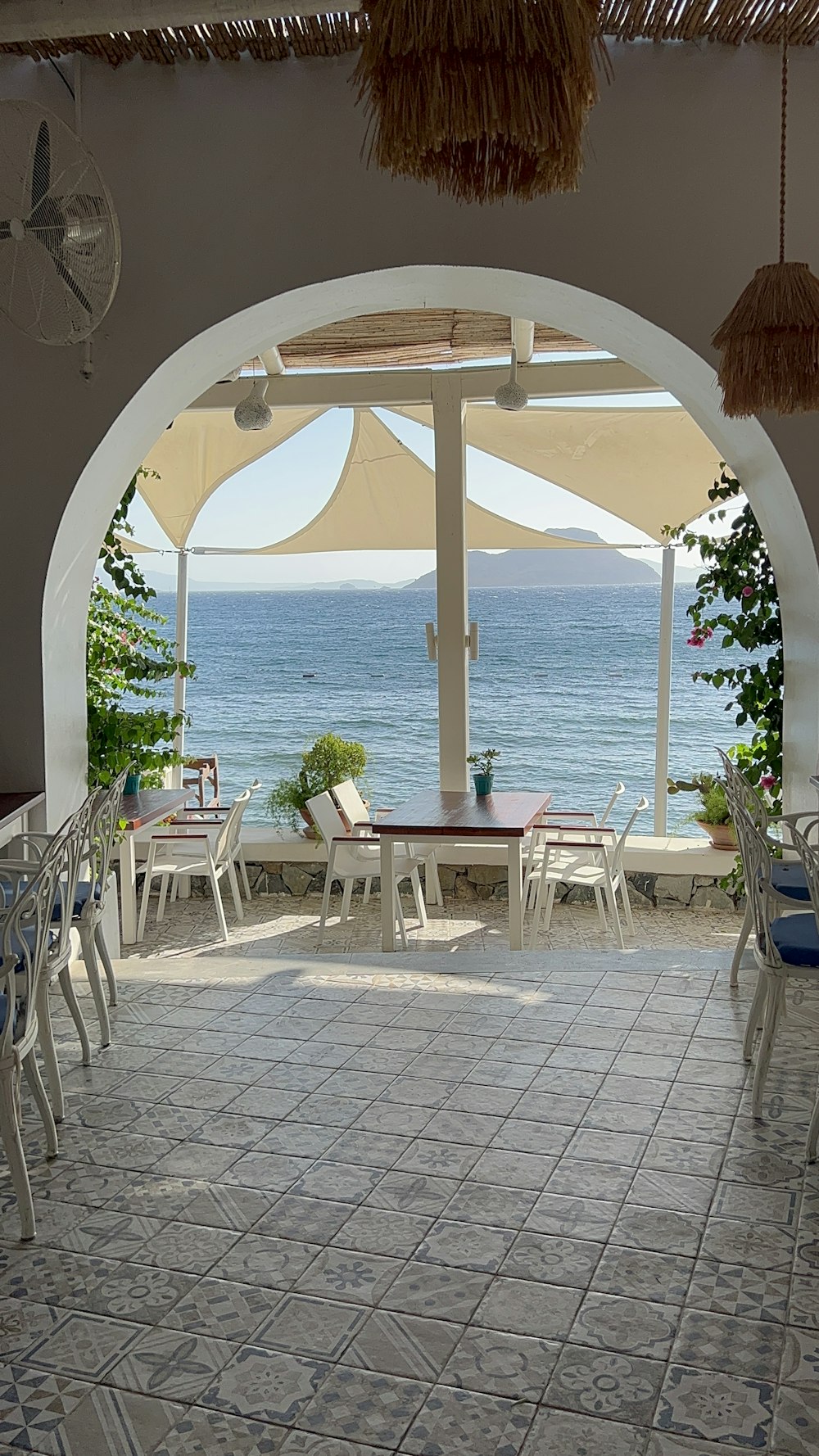 an outdoor dining area with a view of the ocean