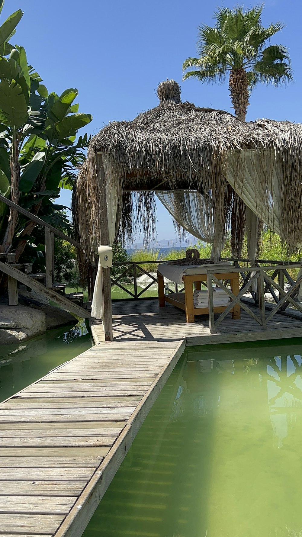 a gazebo next to a pool with a table and chairs