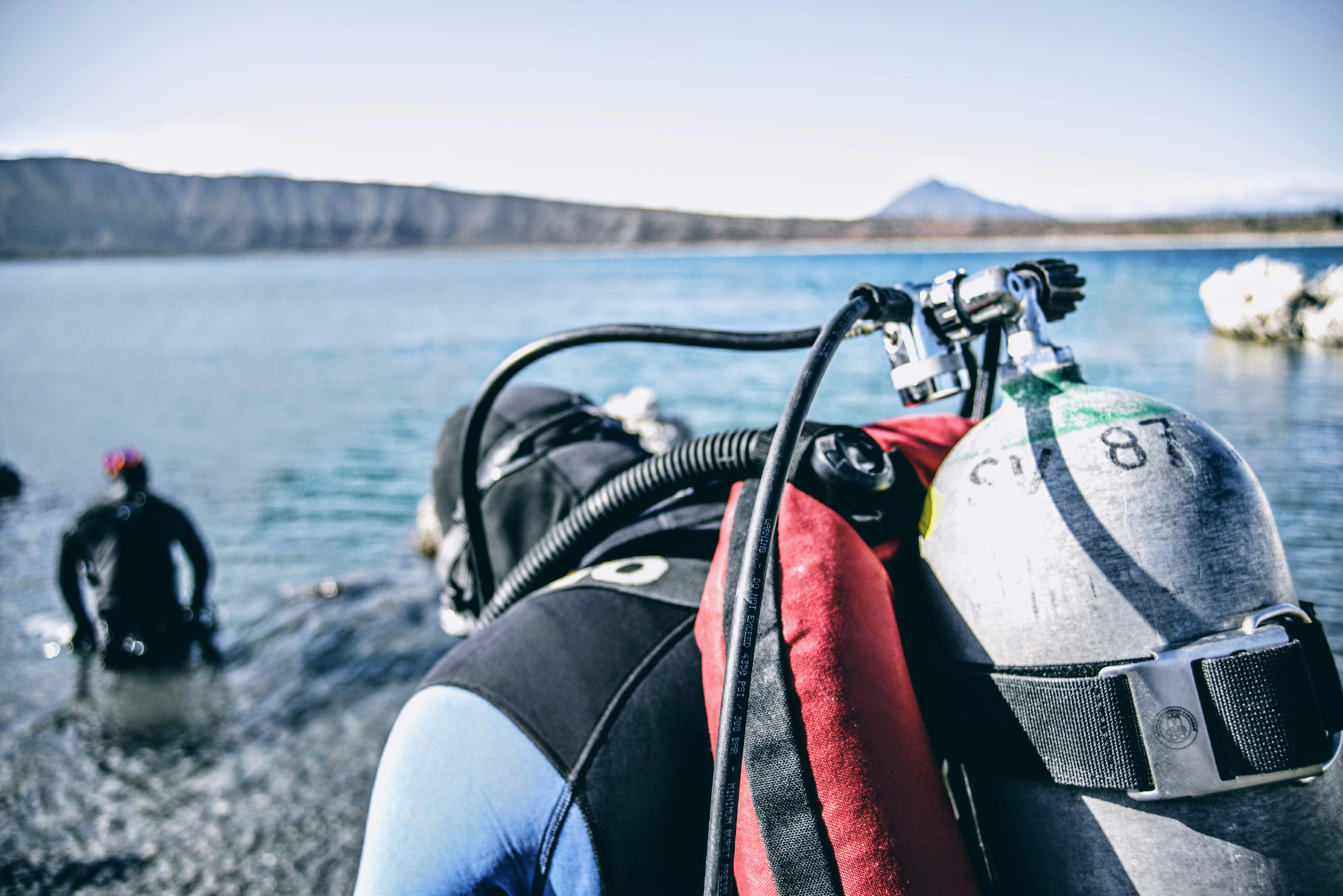 a couple of people standing in the water near a body of water