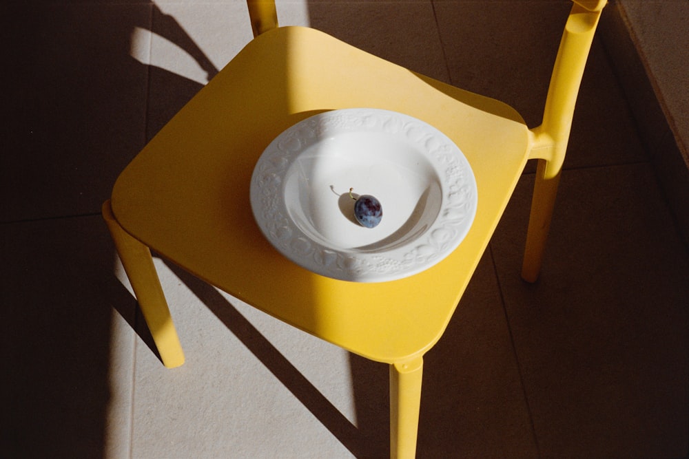 a yellow table with a white bowl on it