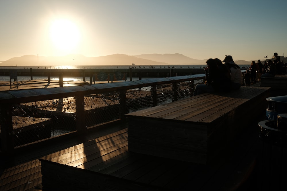 a group of people sitting on top of a wooden deck