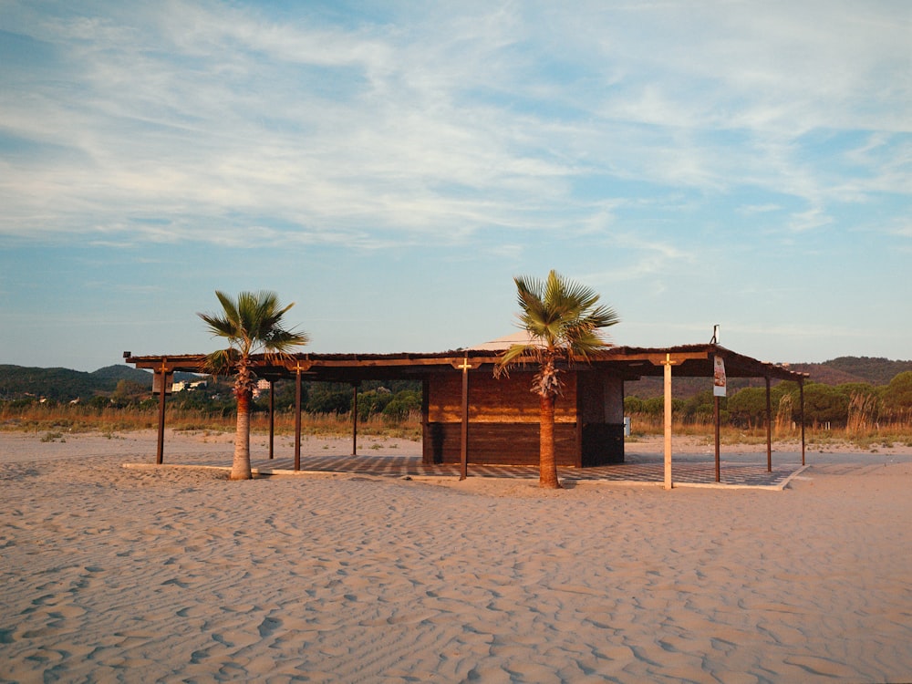 a small hut on a sandy beach with palm trees