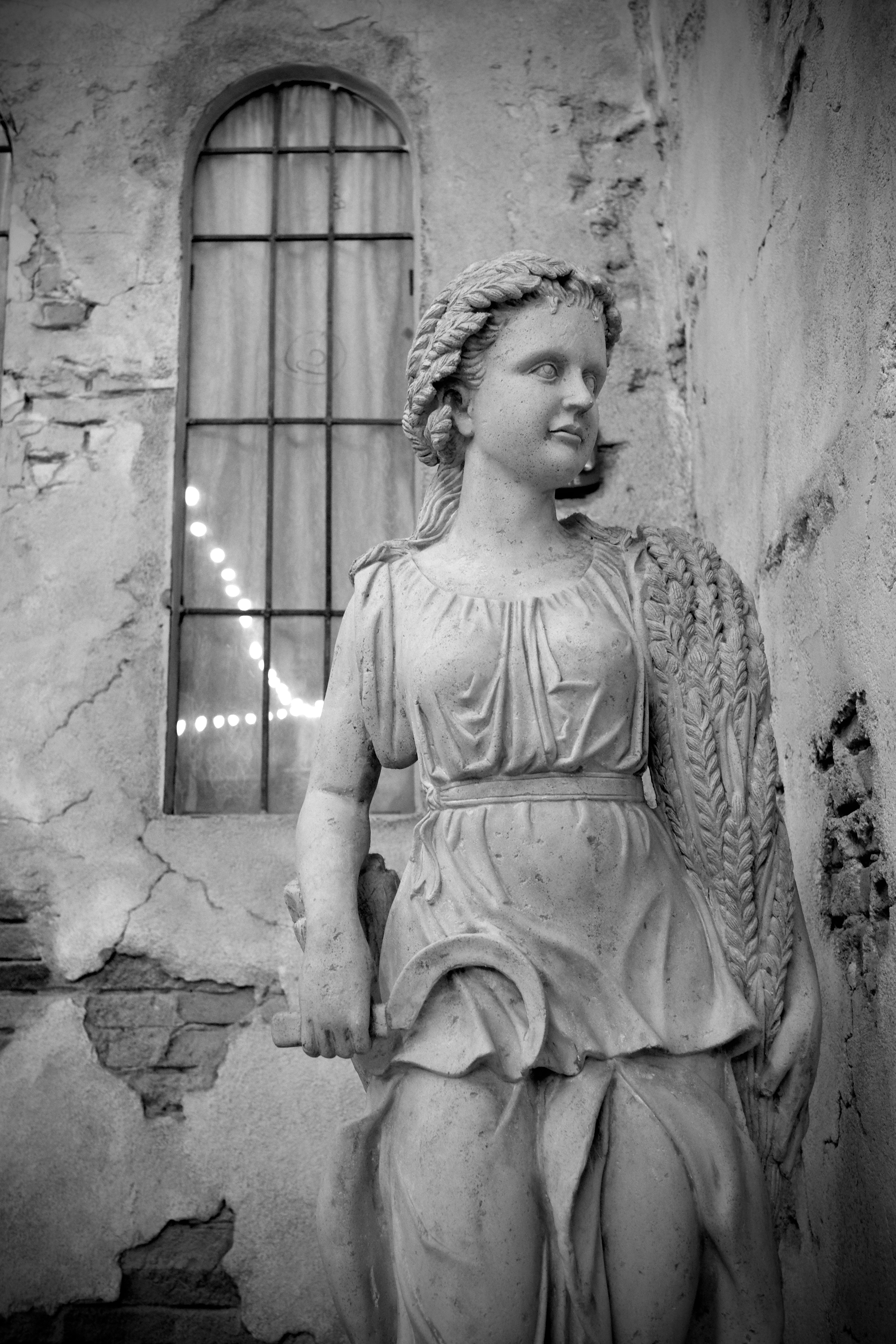 a statue of a woman standing next to a window