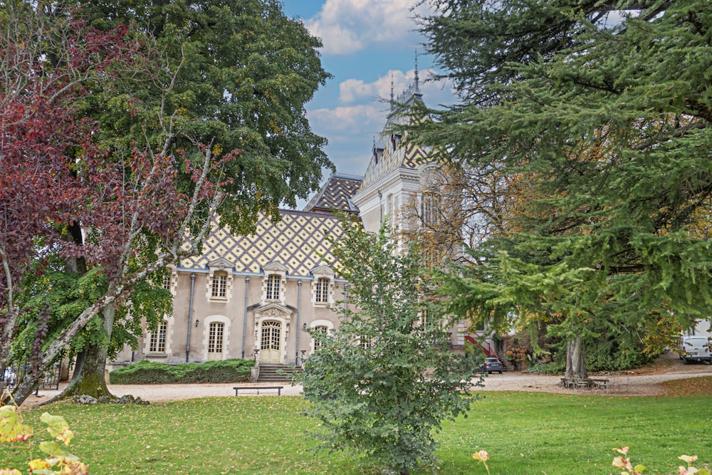 a large white building surrounded by trees and grass