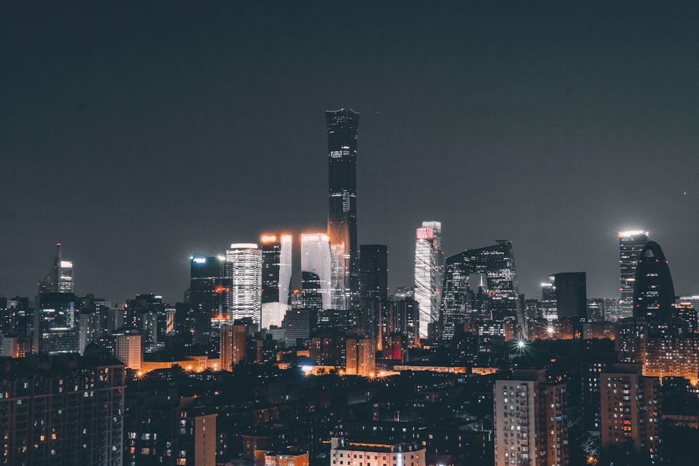 a city skyline at night with skyscrapers lit up