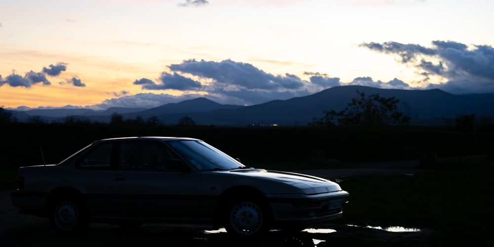 a car parked in a lot with mountains in the background