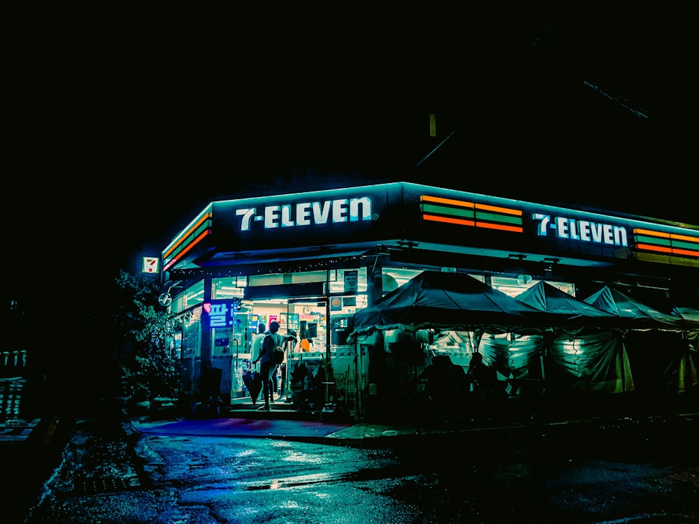 a street corner with a store lit up at night