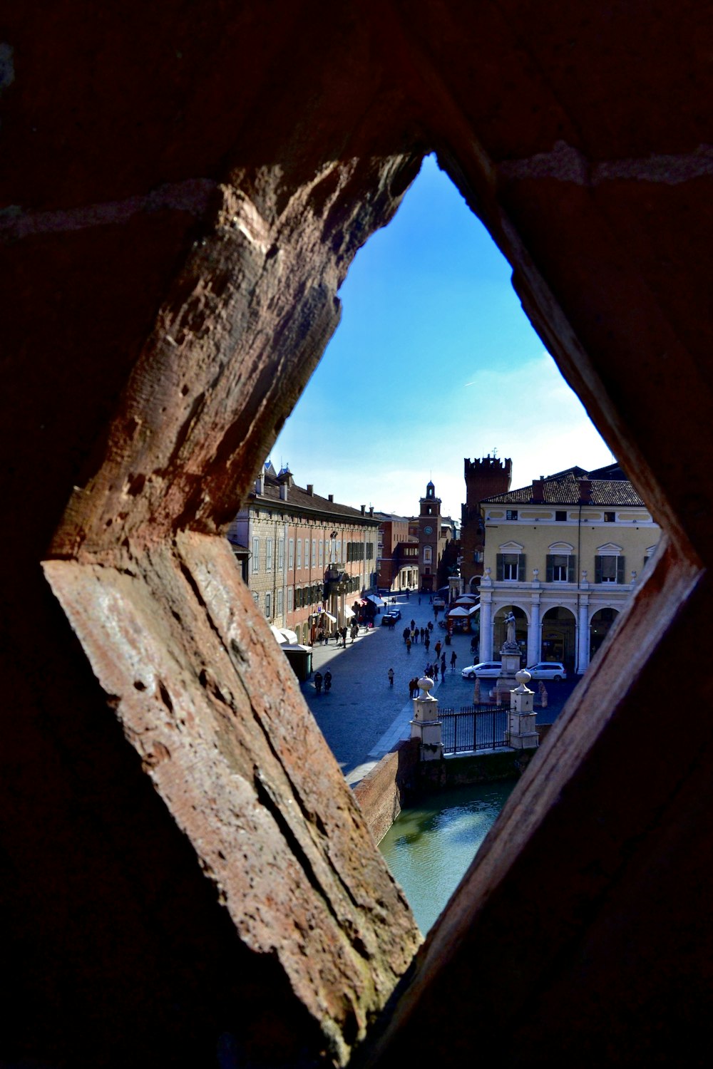 a view of a city through a hole in a wall