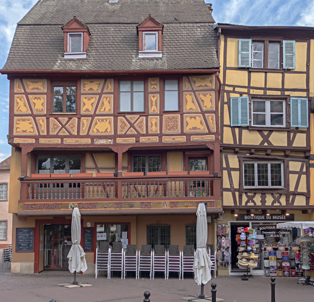 a large building with a lot of tables and umbrellas in front of it