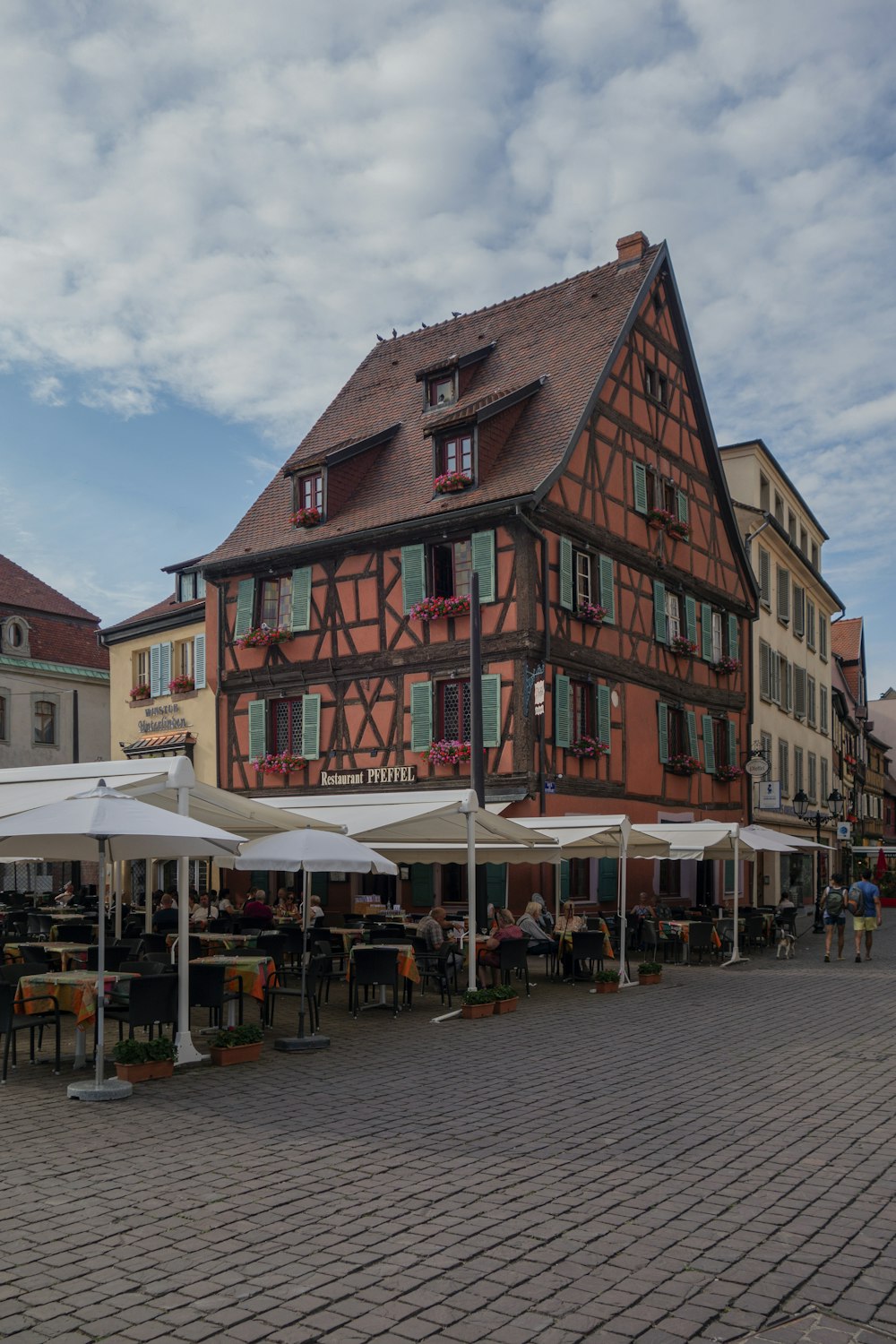 a large building with a lot of tables and umbrellas