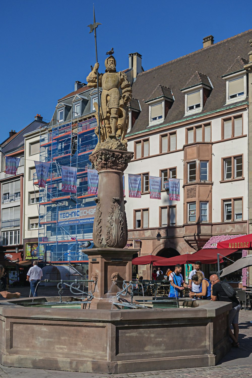 a statue of a man holding a cross in front of a building