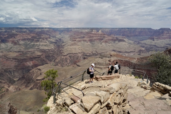 A group of happy travelers enjoying a scenic view of the Grand Canyon during a guided tour.