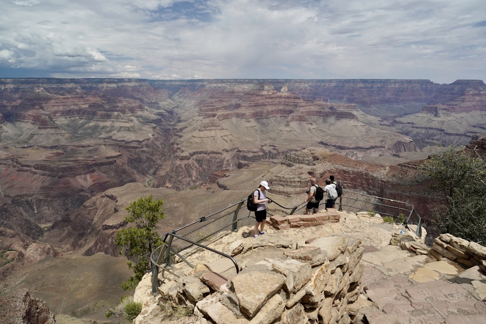 a group of people standing at the edge of a cliff