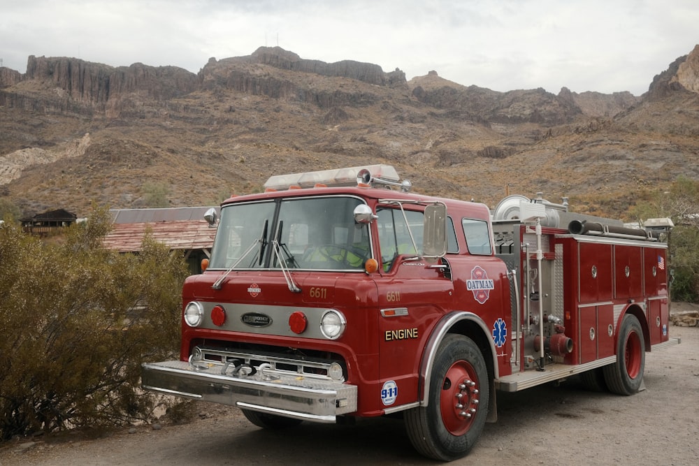 a red fire truck parked in front of a mountain