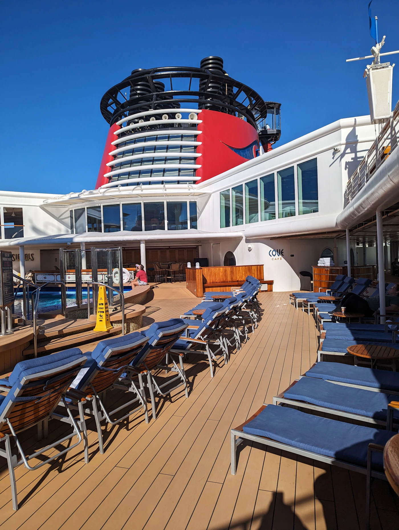 Cubierta de un crucero con piscina y tumbonas bajo el sol del Caribe
