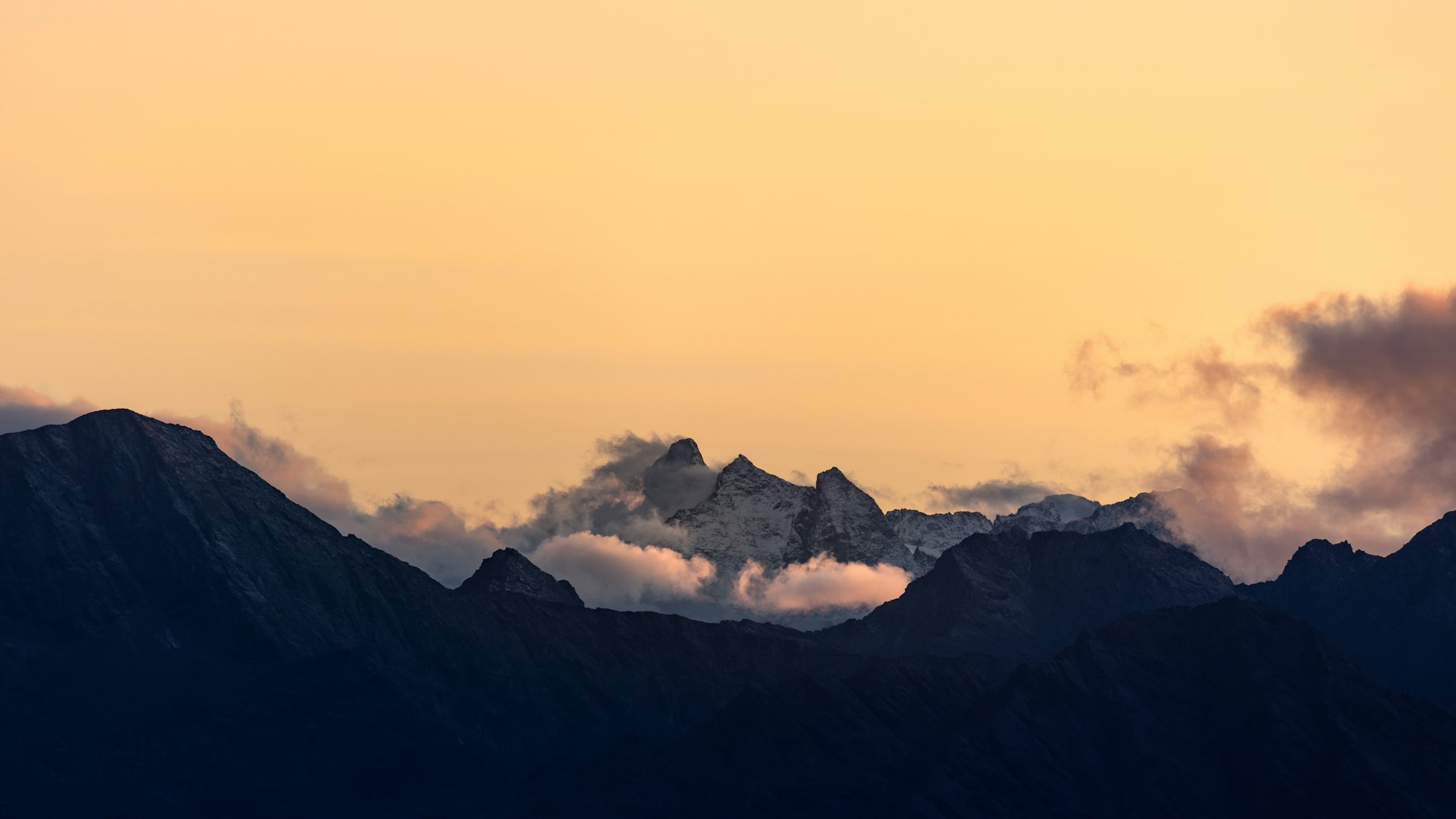 a view of a mountain range with clouds in the sky