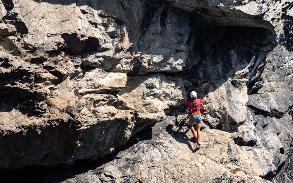 a man climbing up the side of a mountain