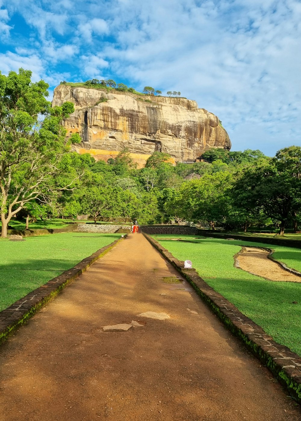 a dirt path leading to a large rock formation