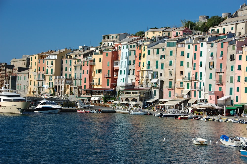 a harbor filled with lots of boats next to tall buildings