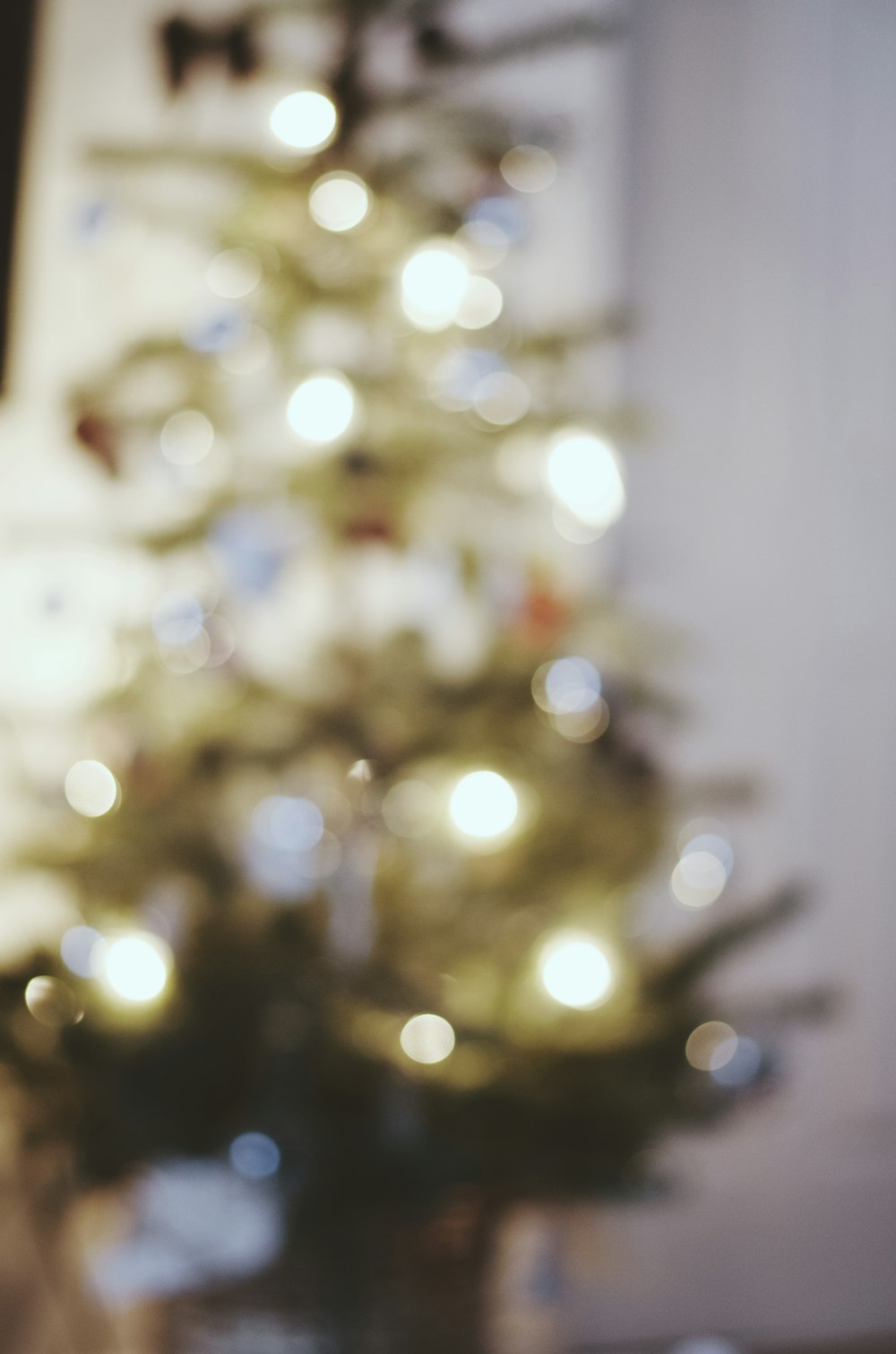 a small white christmas tree in front of a window