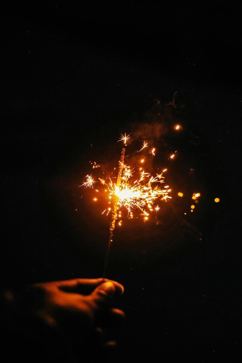 a hand holding a sparkler in the dark