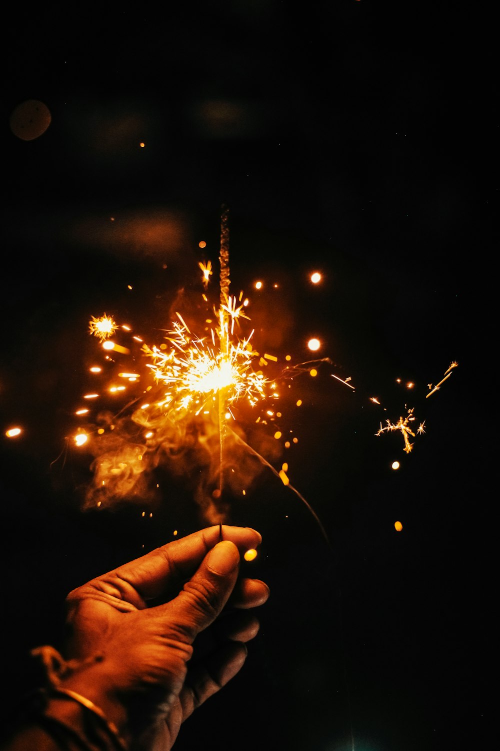 a hand holding a sparkler in the dark