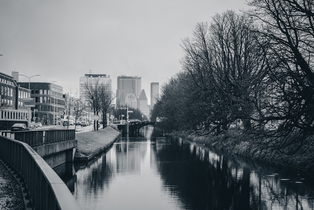 a black and white photo of a river running through a city