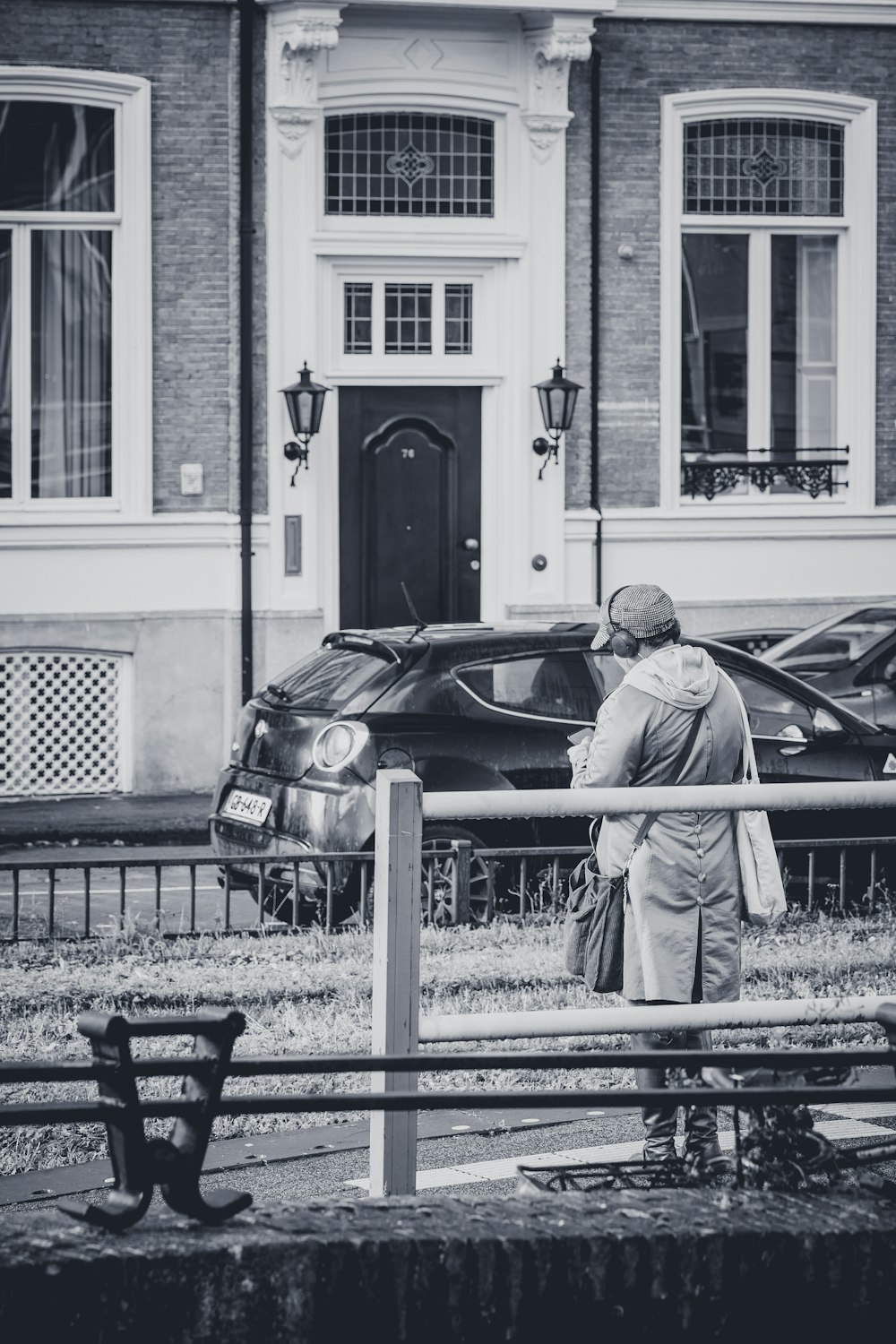 a black and white photo of a man standing in front of a building