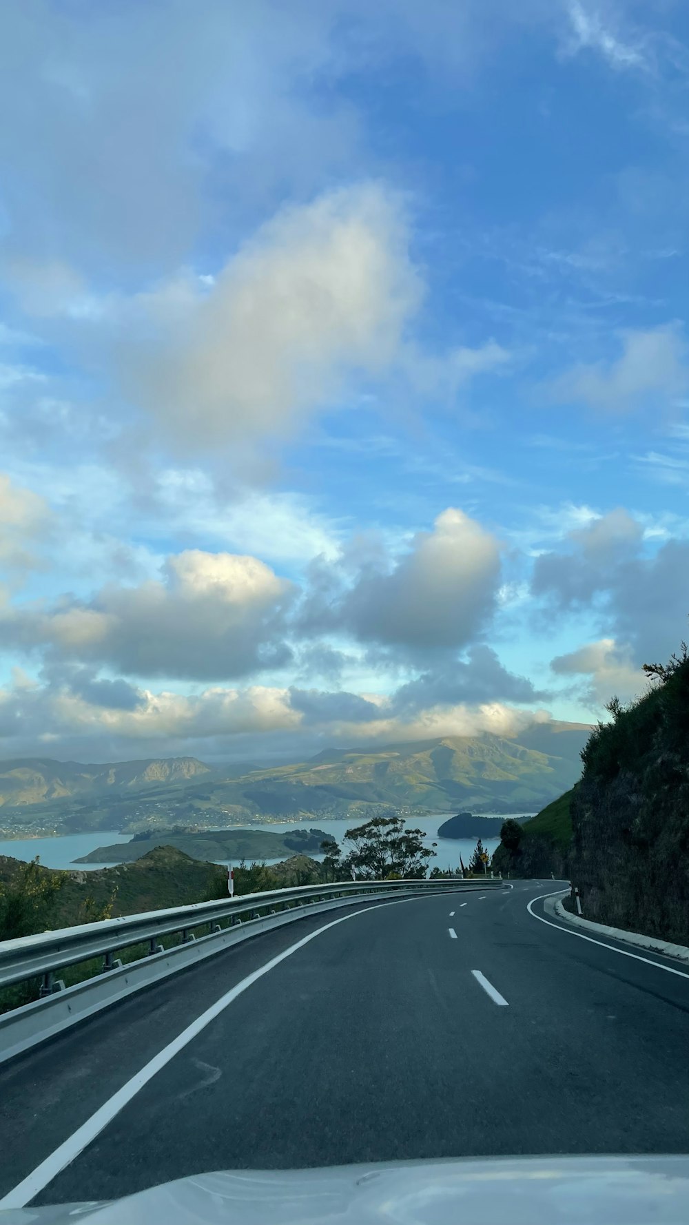 a car driving down a road with mountains in the background