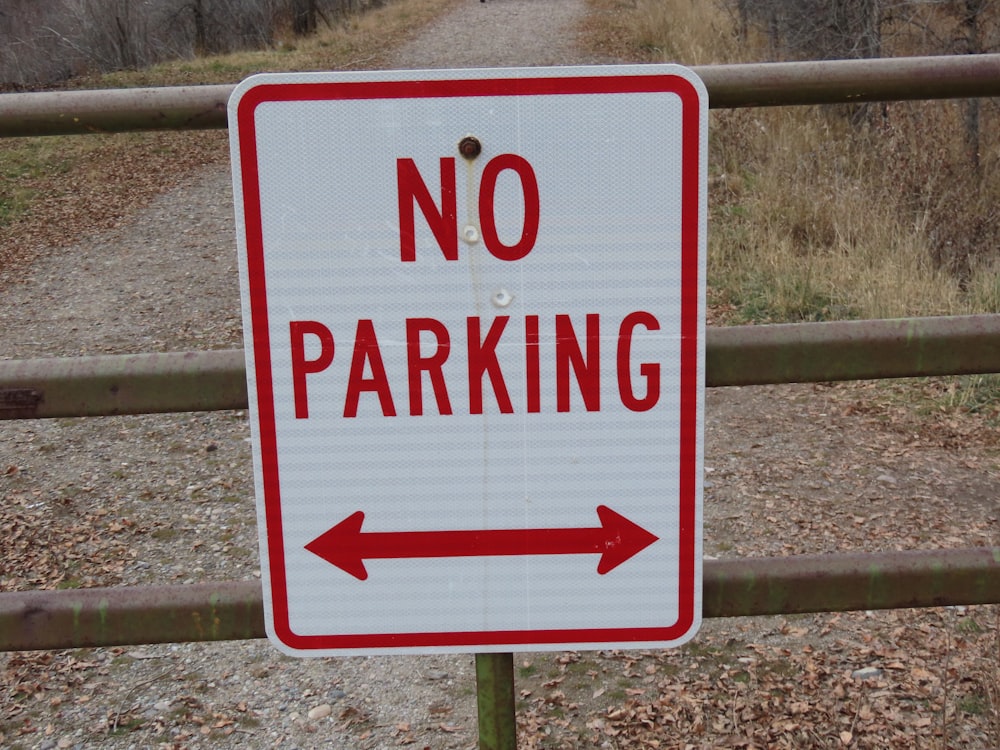 a no parking sign on a wooden fence