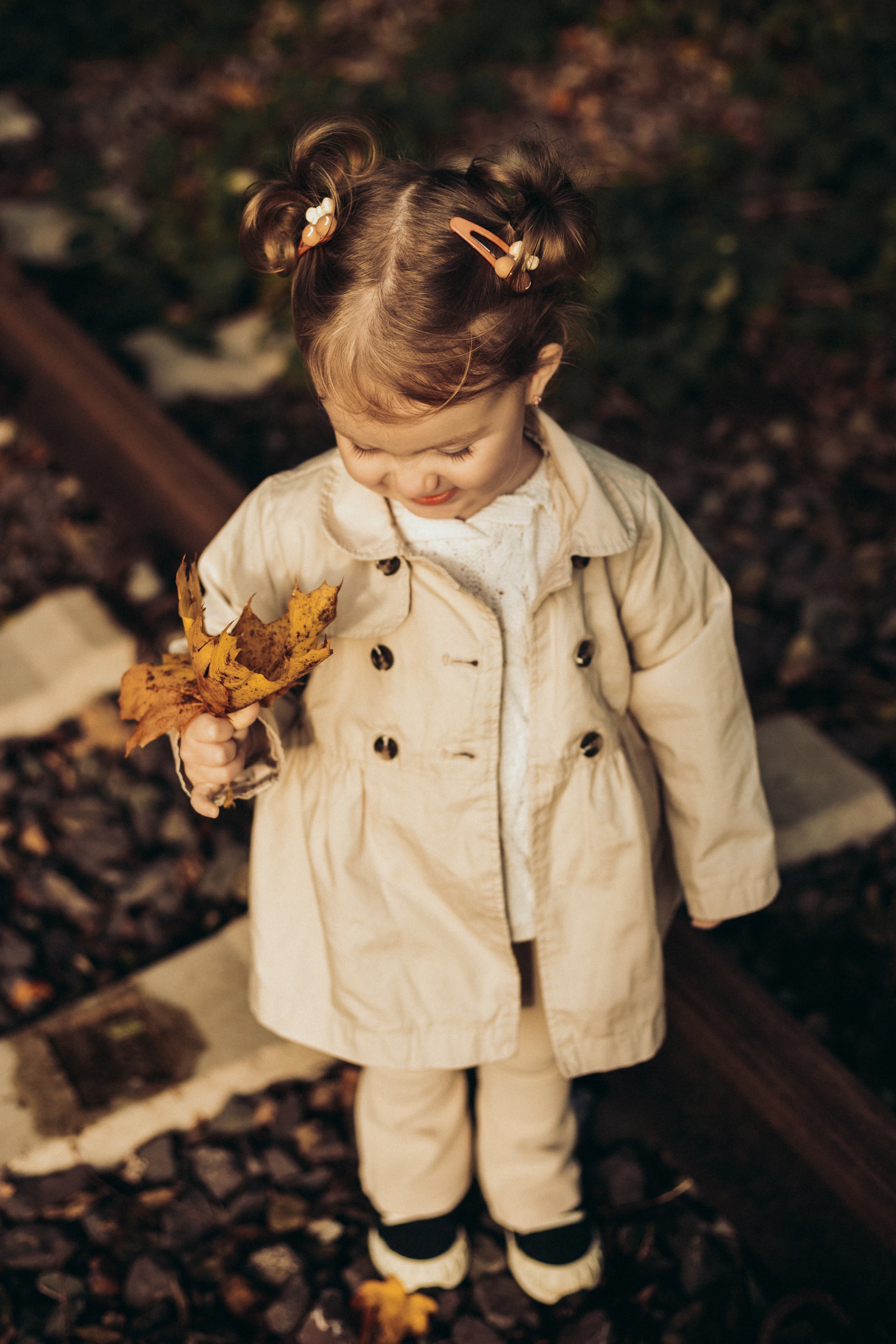a little girl holding a leaf in her hand
