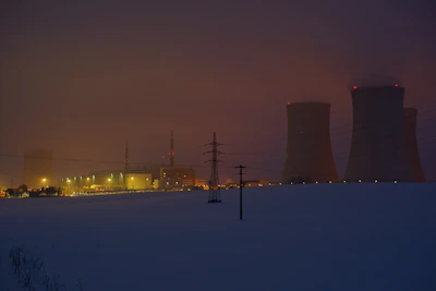A modern power plant bathed in soft purple lighting during twilight, showing clean energy production.