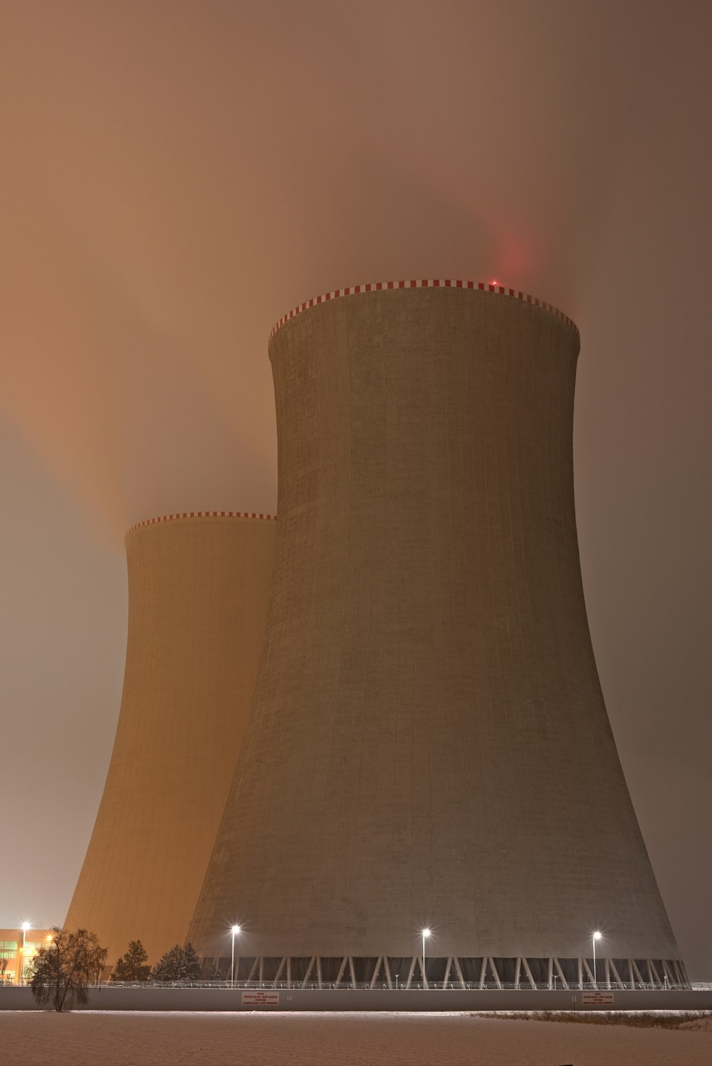 a nuclear power plant at night with a foggy sky