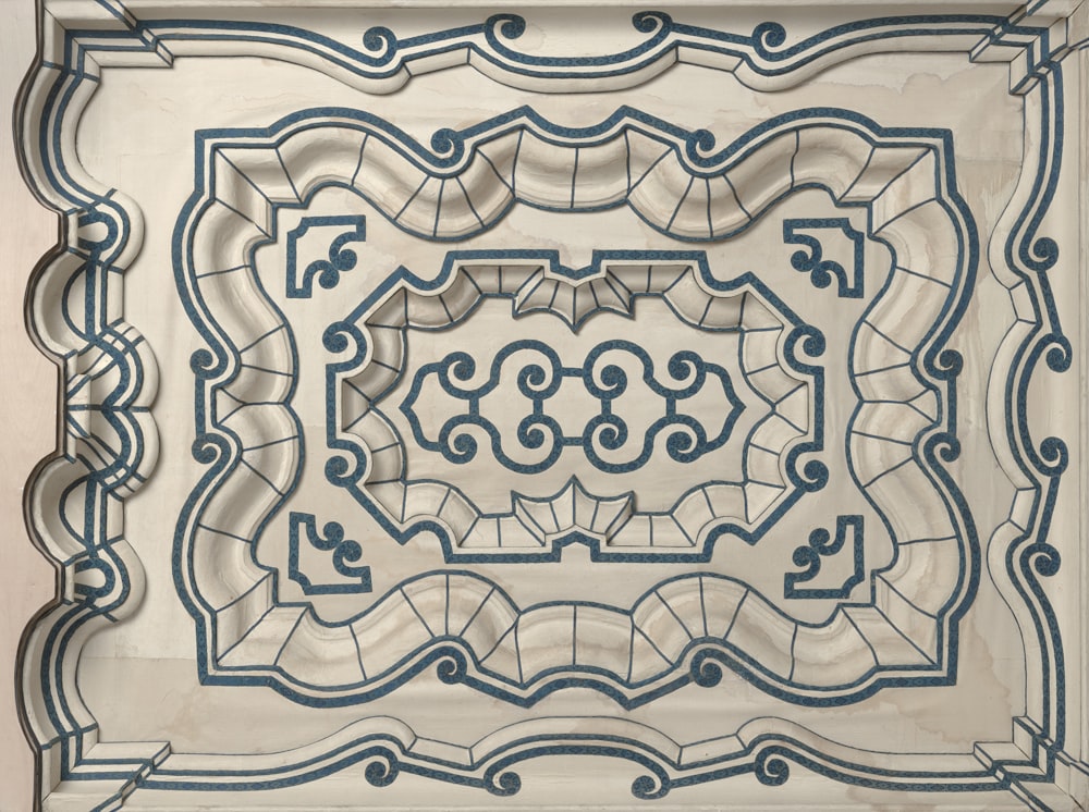 a white and blue tile design on a wall