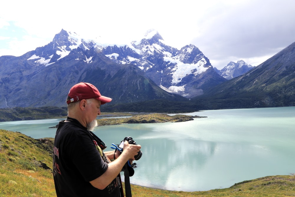 a man is taking a picture of a mountain lake