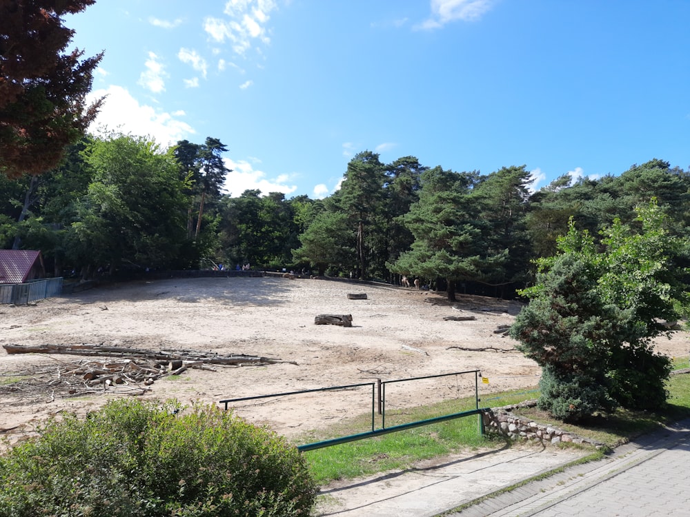 a dirt field surrounded by trees and stairs