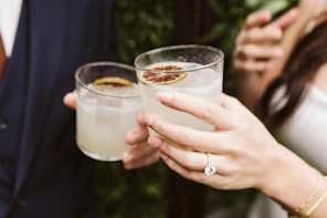 a close up of two people holding drinks