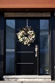 a black front door with a wreath on it