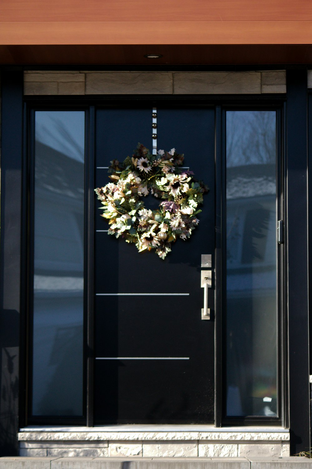 a black front door with a wreath on it