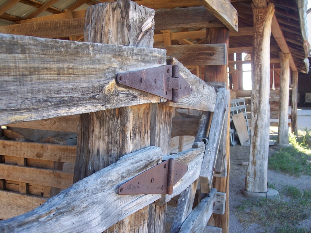 a close up of a wooden fence with a building in the background