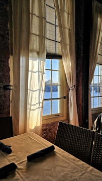 Sunlit dining area showcasing patterned curtains.