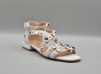 a pair of white shoes with gold studs