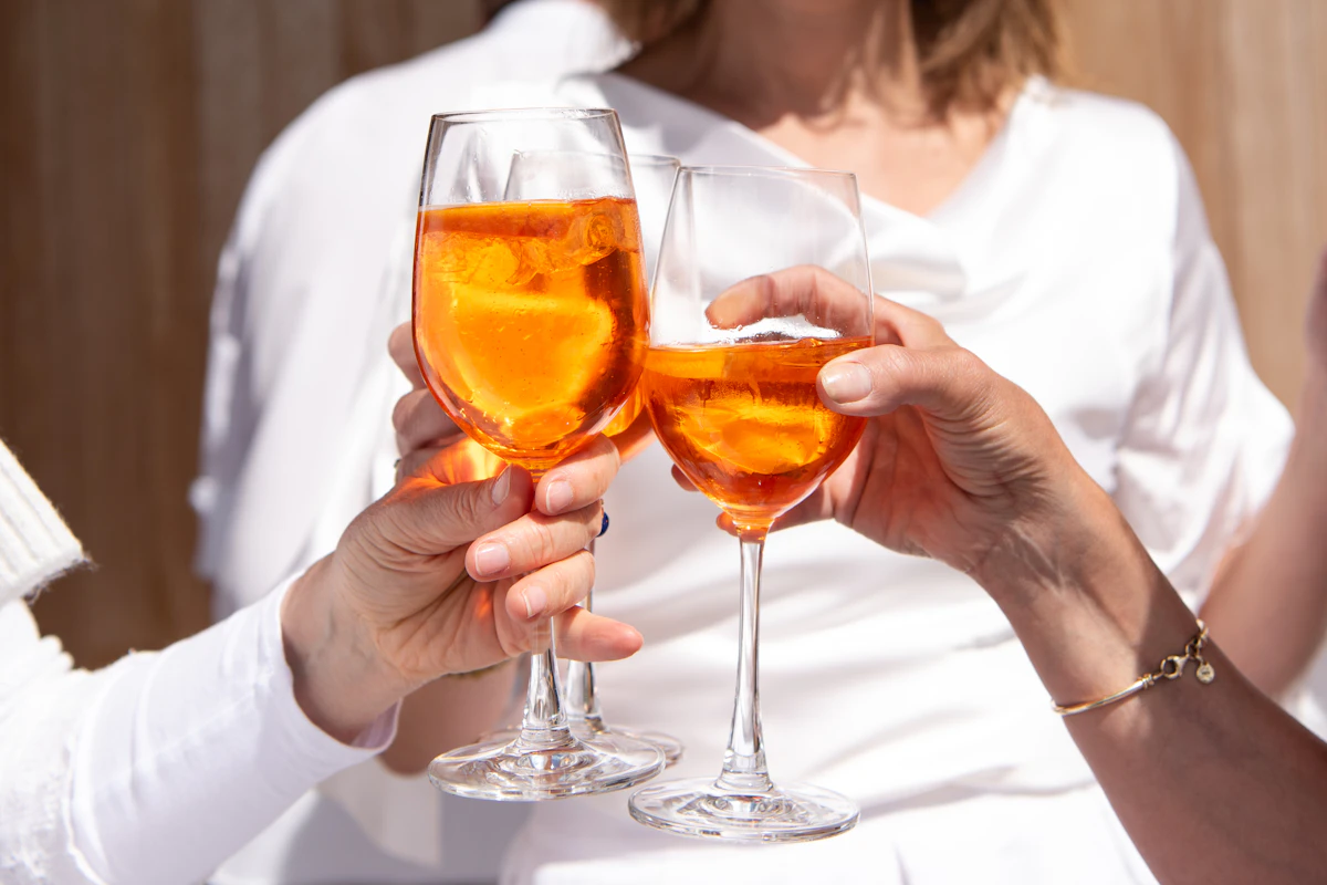 Two glasses of Aperol spritz raised in a toast