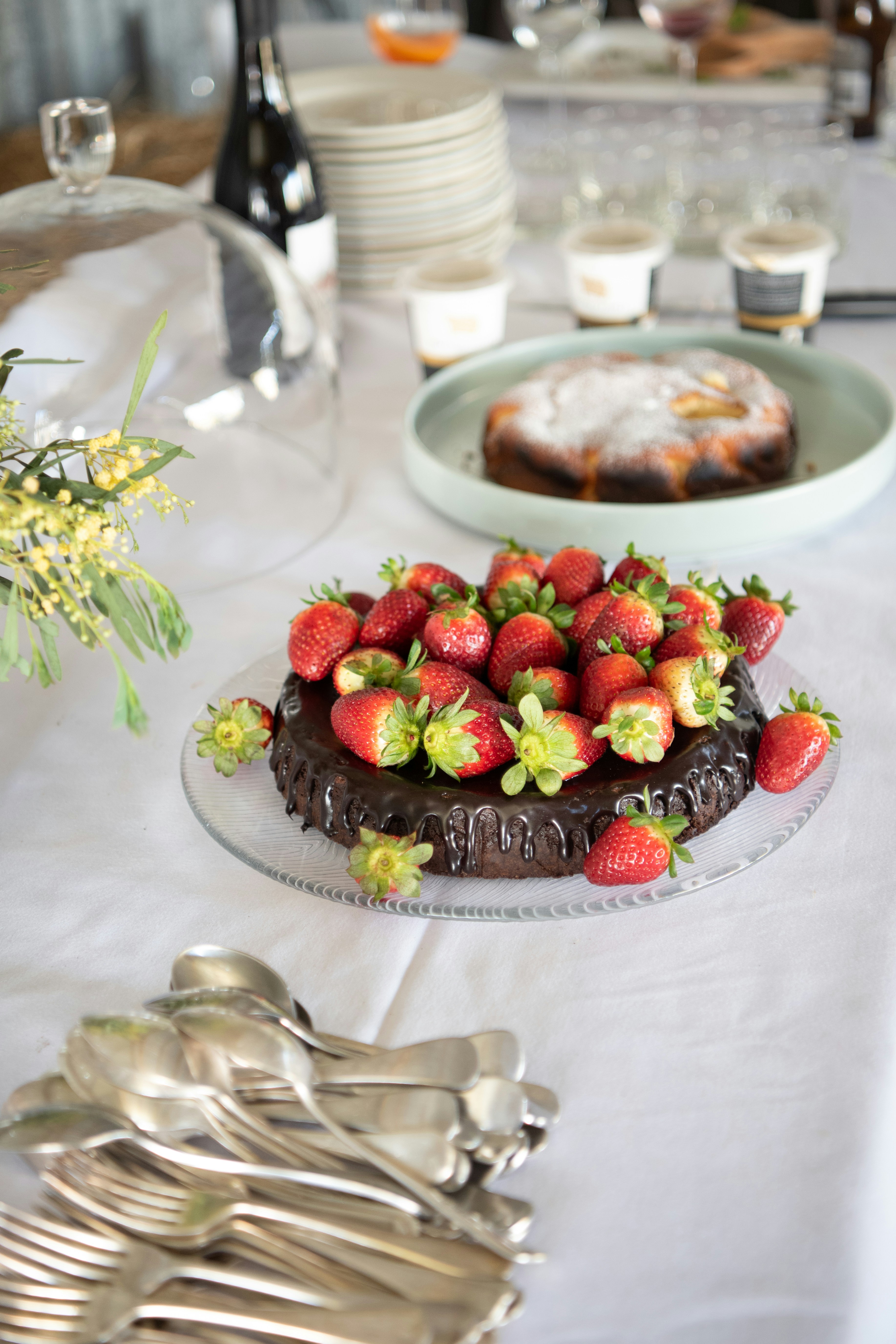 a table topped with a chocolate cake covered in strawberries